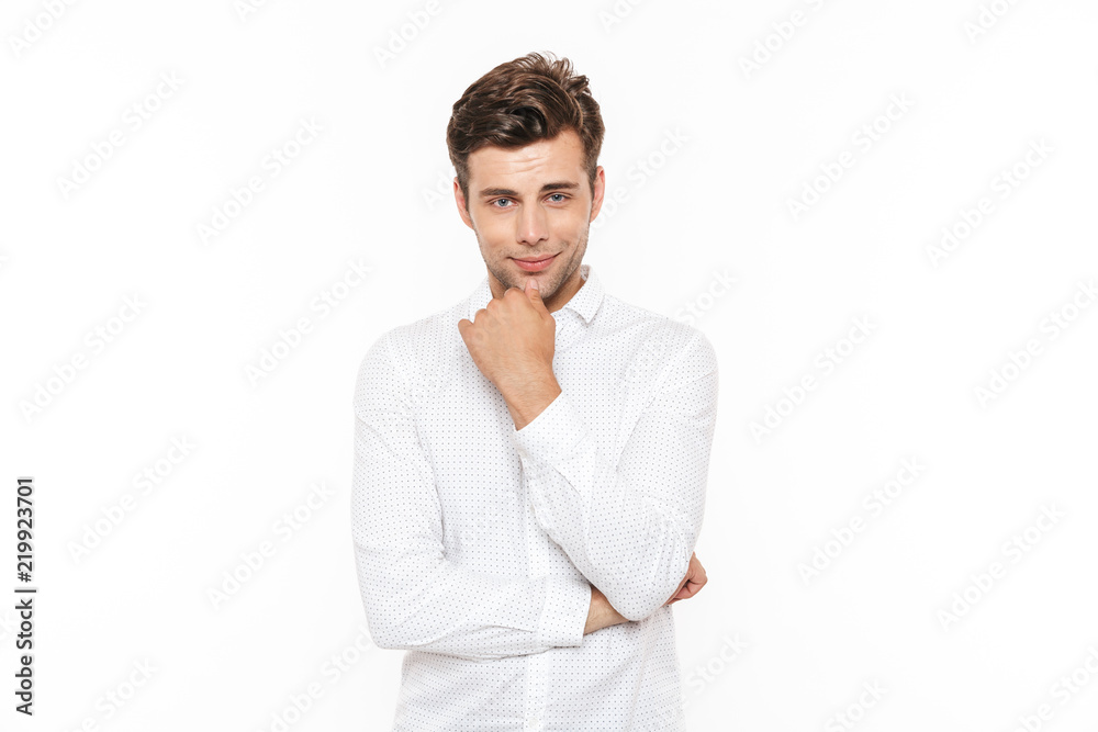 Image of attractive man 30s wearing shirt looking at camera and touching chin, isolated over white background Image of attractive man 30s wearing shirt looking at camera and touching chin, isolated over white background