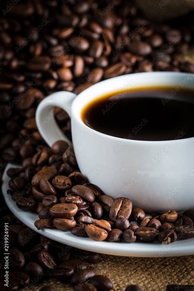 Coffee cup and beans on a rustic background. Coffee Espresso and a piece of cake with a curl. Cup of Coffee and coffee beans on table. Coffee cup and beans on a rustic background. Coffee Espresso and a piece of cake with a curl. Cup of Coffee and coffee beans on table.