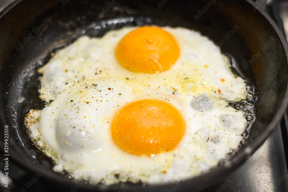 two eggs cooked in a black cast iron skillet two eggs cooked in a black cast iron skillet