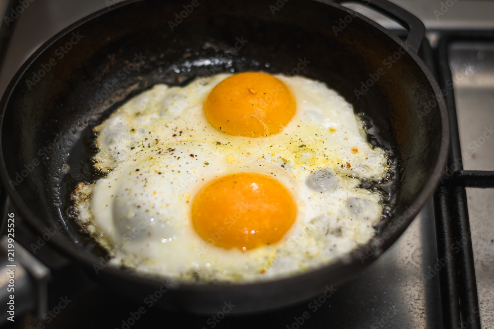 two eggs cooked in a black cast iron skillet two eggs cooked in a black cast iron skillet