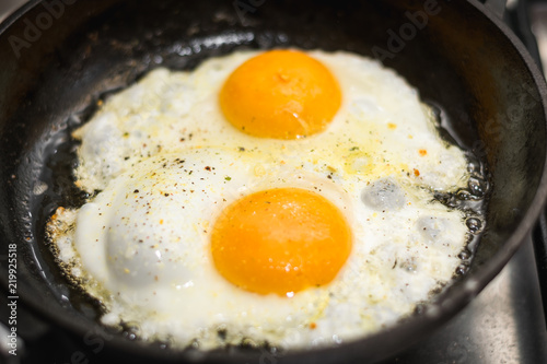 two eggs cooked in a black cast iron skillet
