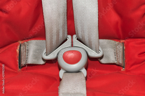 gray seat belts on a red car child seat