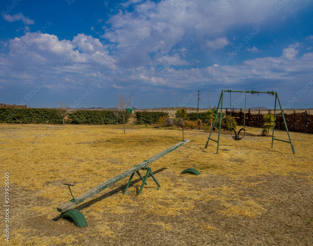 Empty playground against a background of blue skies and white clouds image with copy space in landscape format Empty playground against a background of blue skies and white clouds image with copy space in landscape format