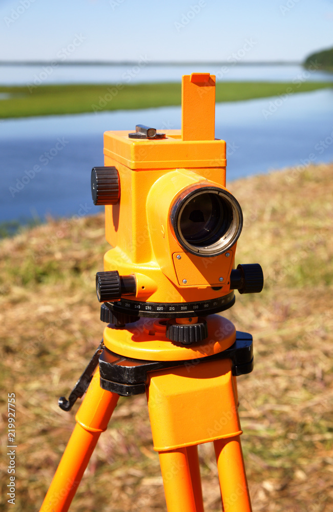 Optical level close-up against the background of a river valley
