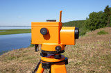 Optical level close-up against the background of a river valley and taiga