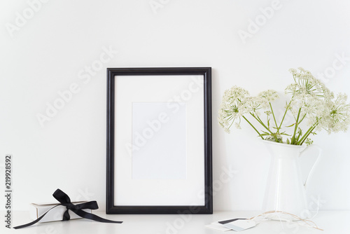 Black portrait frame a4 mock up with a Aegopodium podagraria in wight jug and present box. Mockup for quote, promotion, headline, design. Template for small businesses photo