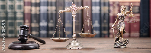 Lady Justice, Scales of Justice and Judge Gavel on a  wooden background.