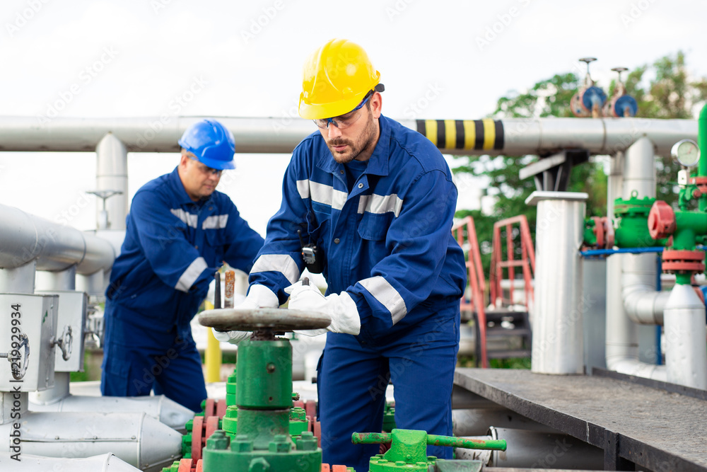 © zorandim75 - Two petrochemical workers inspecting pressure valves on a fuel tank © zorandim75 - Two petrochemical workers inspecting pressure valves on a fuel tank