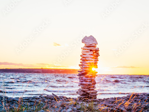 solnegång med solen som lyser genom staplade stenar med text inristat I love U photo