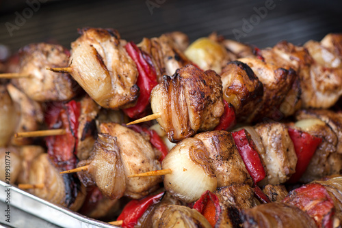 Close up of traditionally grilled pork and beef meat on a wooden stick. Eastern European traditional shish kebab with grilled vegetables.