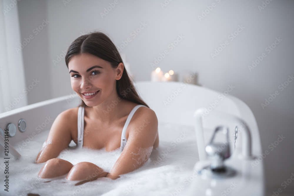 Portrait of beaming lady having leisure while locating in warm water indoor. She looking at camera. Glad female during spa procedure concept Portrait of beaming lady having leisure while locating in warm water indoor. She looking at camera. Glad female during spa procedure concept