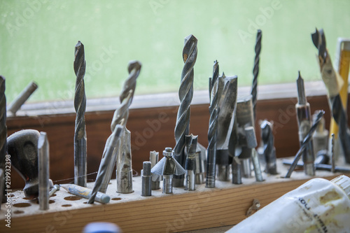 Different sizes and shapes of drills shaped and designed for wood driling nicely placed in a special wooden board. photo