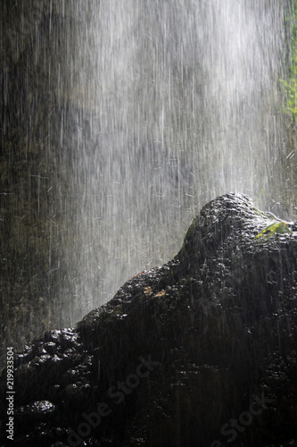 water from the falls falls on the rock and breaks into drops