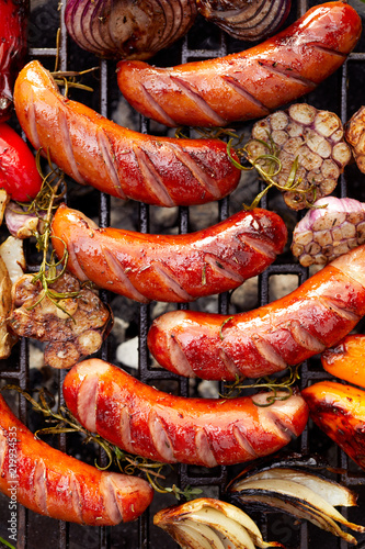 Grilled sausages and vegetables with addition spices  on a grill plate , top view photo