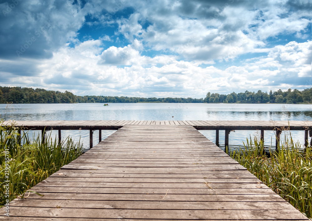Naklejka premium Beautiful summer landscape with dramatic sky, wooden pier on the lake, Trakai, Lithuania