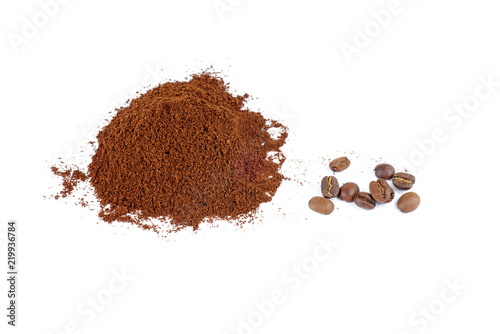 Pile of the ground coffee and few beans isolated on white background