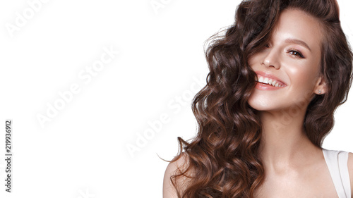 Beautiful young girl in white dress with natural make-up, hair curls and smile. Beauty face.