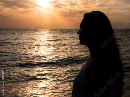 Woman relaxing at the beach during beautiful sunset. Vacation human relaxation