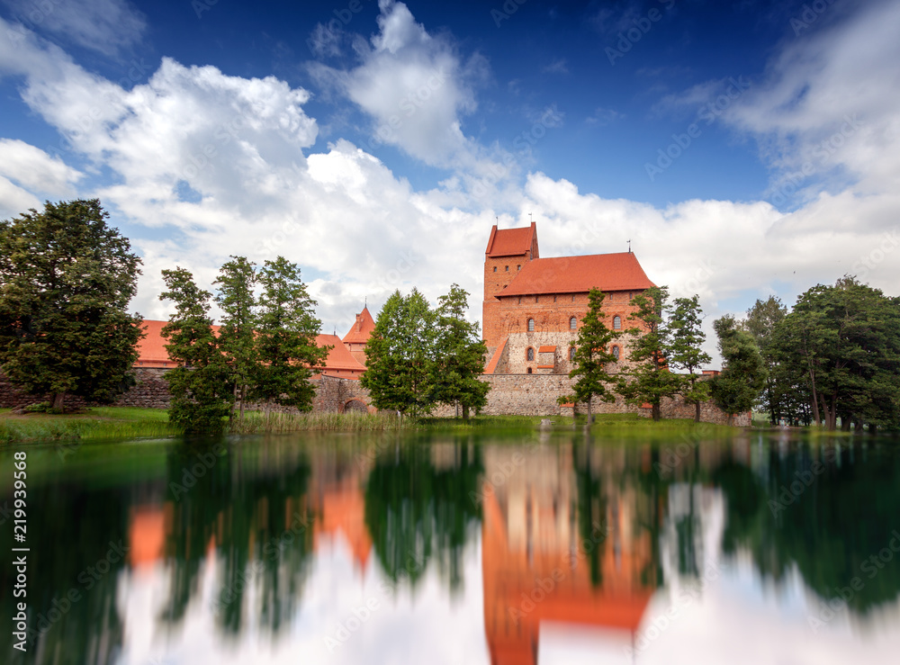 Obraz premium Medieval gothic Trakai Island Castle with stone walls and towers with red tiled roofs in Lake Galve, Lithuania