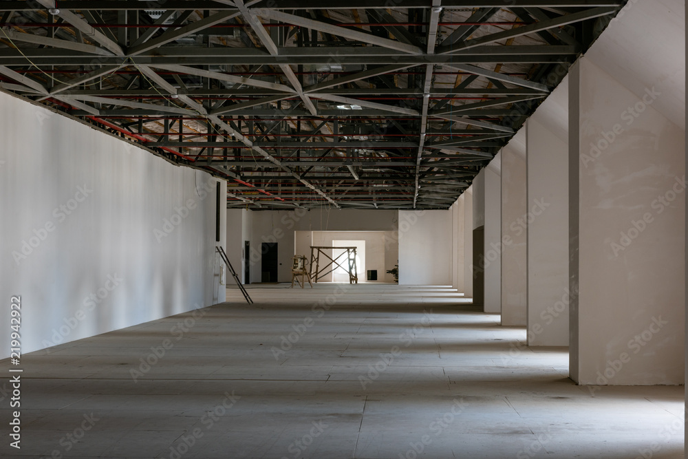 Fototapeta premium House attic under construction. Interior of large unfinished mansard.