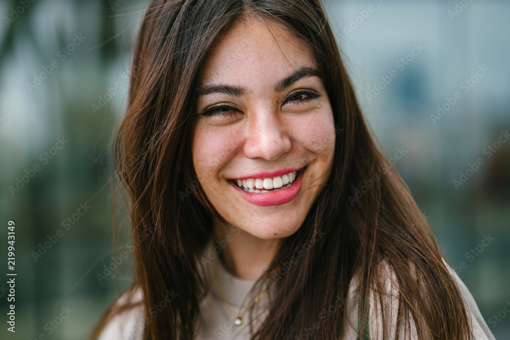 Close up portrait head shot of a young, cute and attractive Japanese Asian woman. She has long brunette hair and beautiful features; she is smiling as she looks into the camera. Close up portrait head shot of a young, cute and attractive Japanese Asian woman. She has long brunette hair and beautiful features; she is smiling as she looks into the camera.