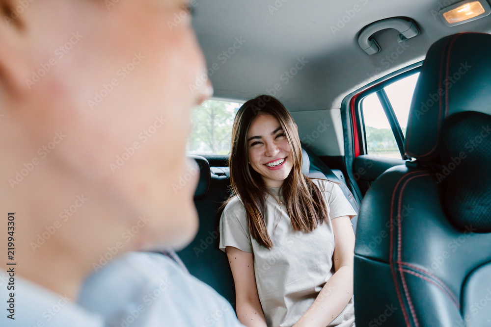 A young attractive Japanese lady is having a hearty conversation with her driver on a ride she booked via ride hailing. A young attractive Japanese lady is having a hearty conversation with her driver on a ride she booked via ride hailing.