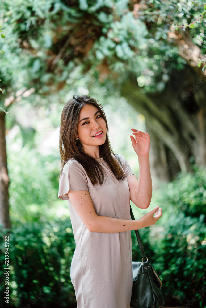 Portrait of a young, attractive and elegant Japanese Asian tourist posing in a park during the day. She is happy to be outdoors for a break from her hectic schedule at work. Portrait of a young, attractive and elegant Japanese Asian tourist posing in a park during the day. She is happy to be outdoors for a break from her hectic schedule at work.