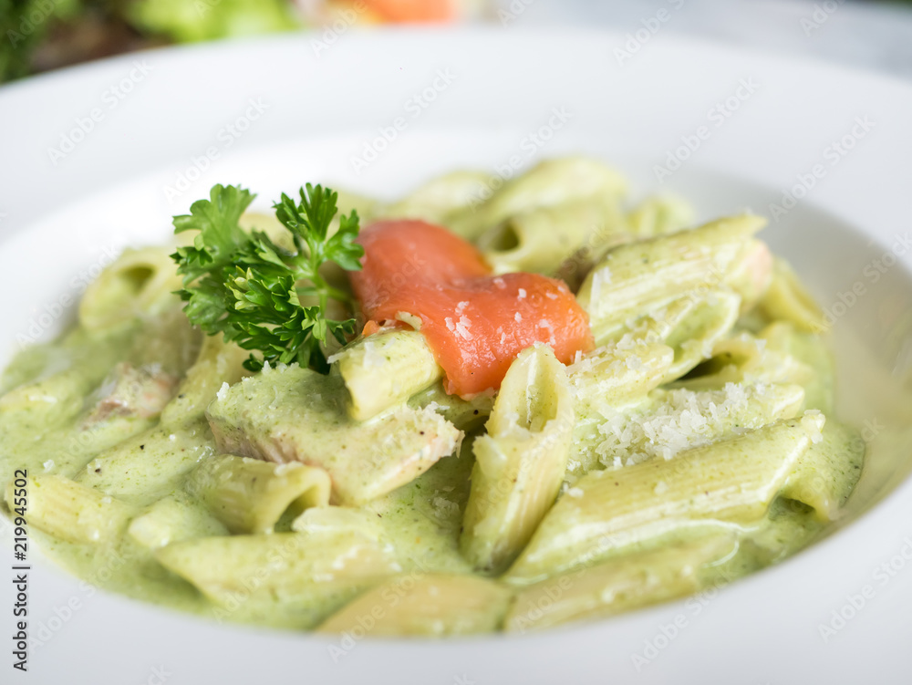 Traditional Italian Penne pasta with pesto sauce and salmon.