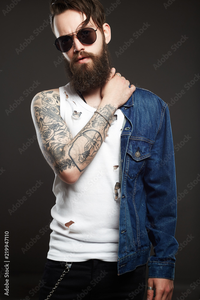 Plakat modny przystojny mężczyzna z tatuażem i okulary przeciwsłoneczne