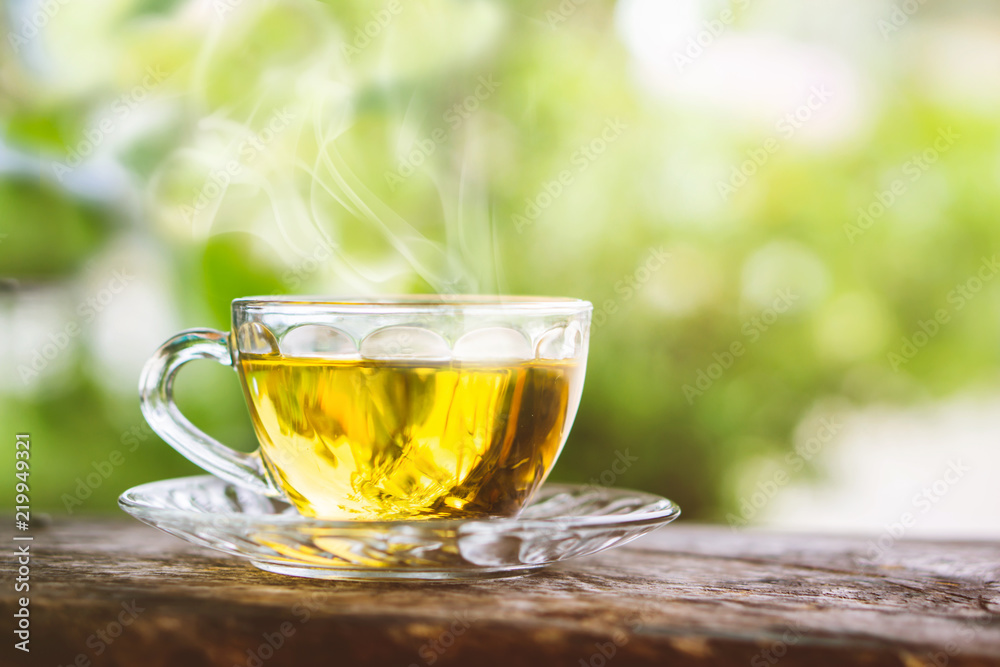 hot tea cup on wooden table with background of nature sunlight in the morning hot tea cup on wooden table with background of nature sunlight in the morning