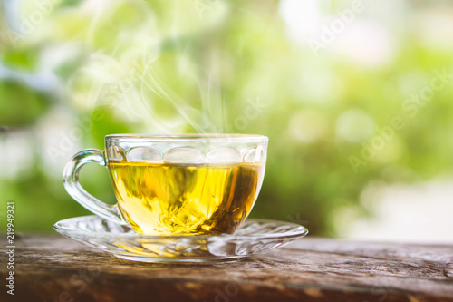 hot tea cup on wooden table with background of nature sunlight in the morning 