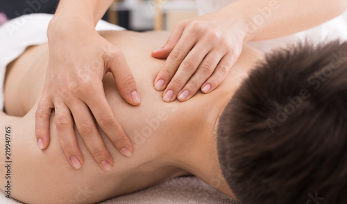 Man receiving relaxing back massage in spa