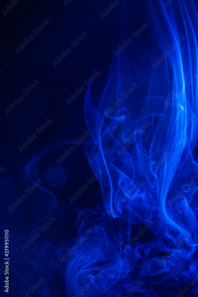 Fototapeta premium Blue smoke on black background.