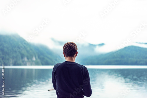 Lonely young man fishing on Vidraru Lake