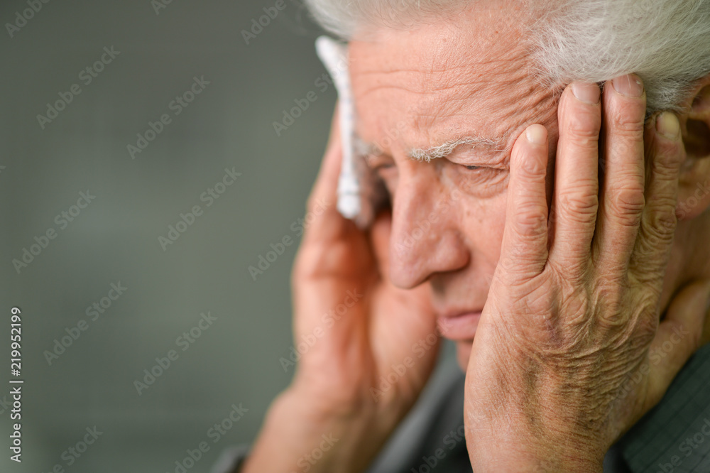 Close up portrait of senior man with headache holding Close up portrait of senior man with headache holding