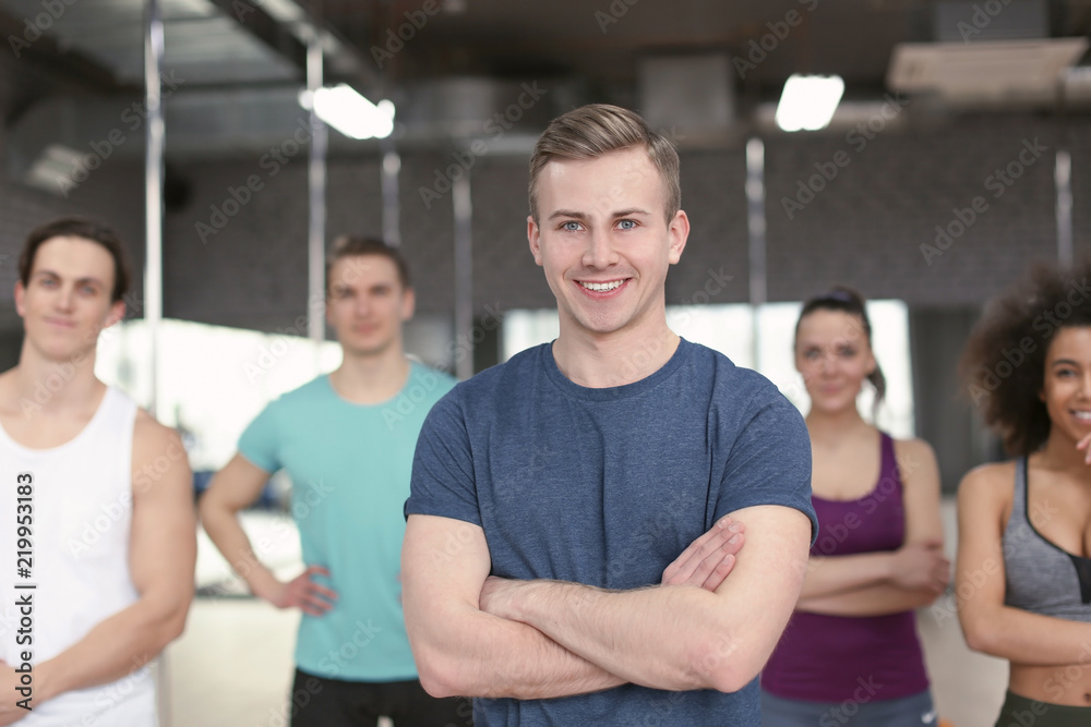 Sporty man with group of athletes in gym Sporty man with group of athletes in gym
