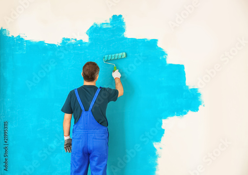 Male painter in uniform wor...