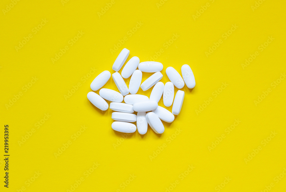 A lot of pills on a yellow background, concept of health A lot of pills on a yellow background, concept of health