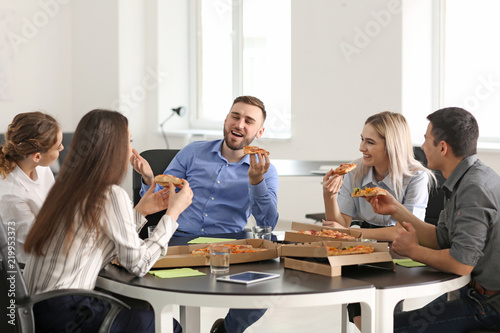 Young people eating pizza a...