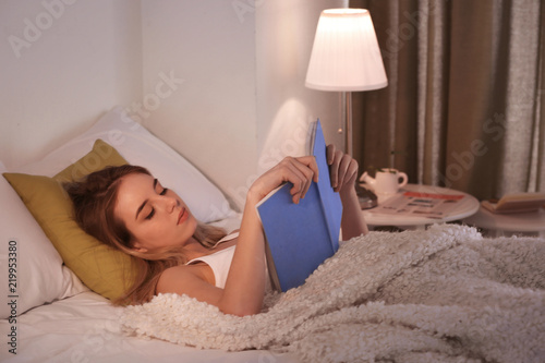 Young woman reading book in...
