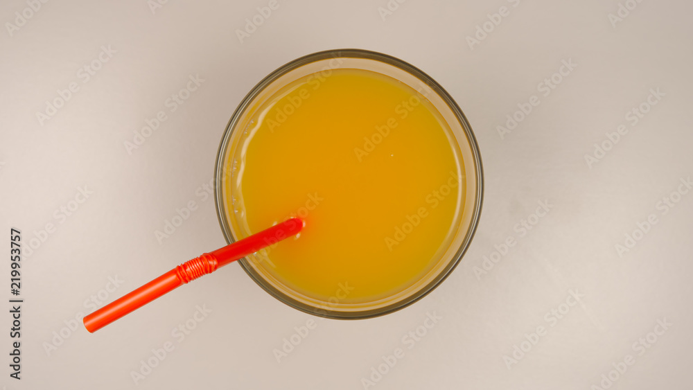 TOP VIEW: Fresh orange juice with a straw in a glass TOP VIEW: Fresh orange juice with a straw in a glass