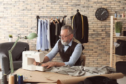 Mature tailor working on se...