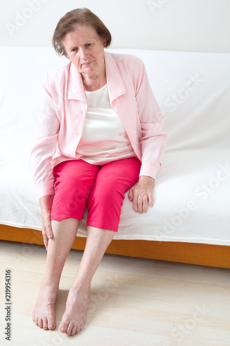 Seniorin massiert ihr Bein