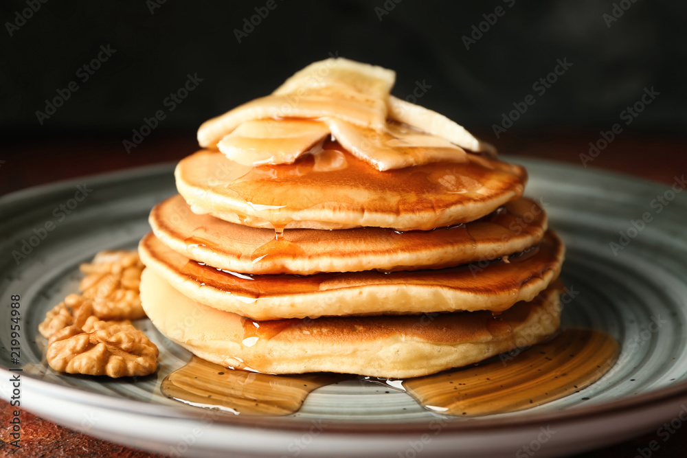 Tasty pancakes with walnuts and sliced banana on plate Tasty pancakes with walnuts and sliced banana on plate