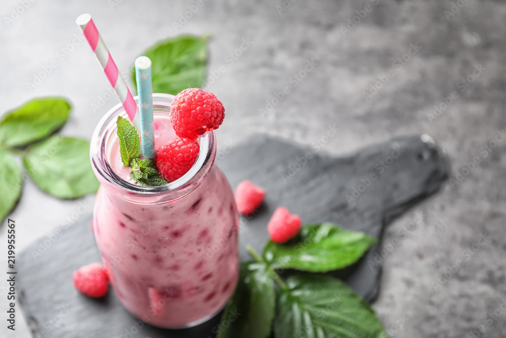 Glass bottle with tasty raspberry smoothie on light table Glass bottle with tasty raspberry smoothie on light table