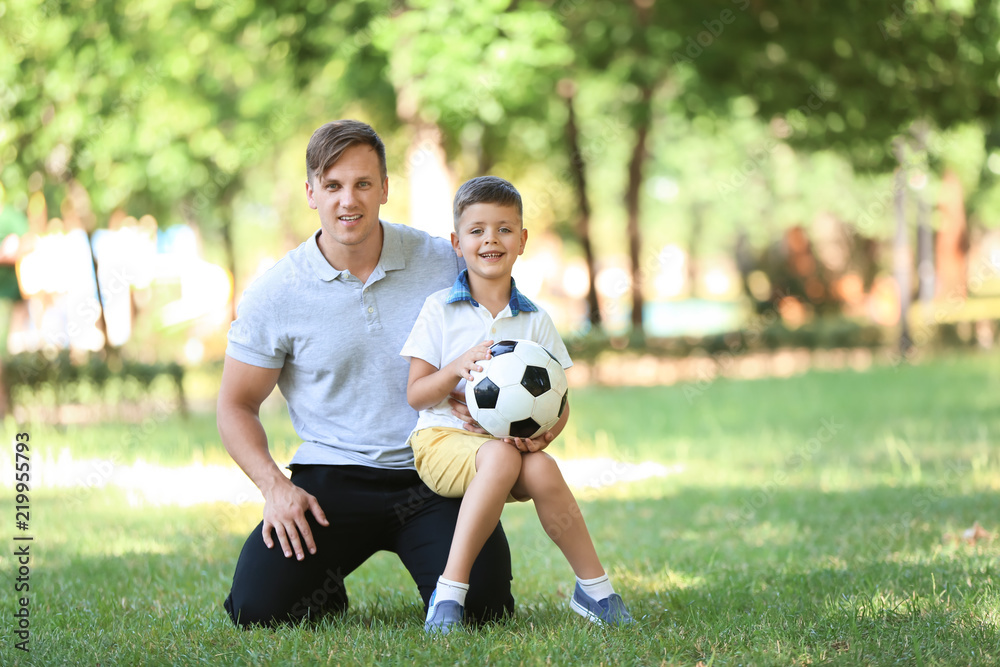 Little boy and his dad with soccer ball in park Little boy and his dad with soccer ball in park