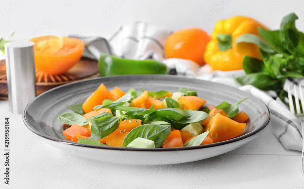 Plate with fresh vegetable salad on white table