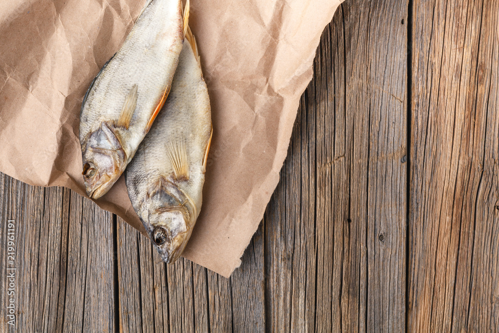 close-up dried fish on a dark wooden background close-up dried fish on a dark wooden background
