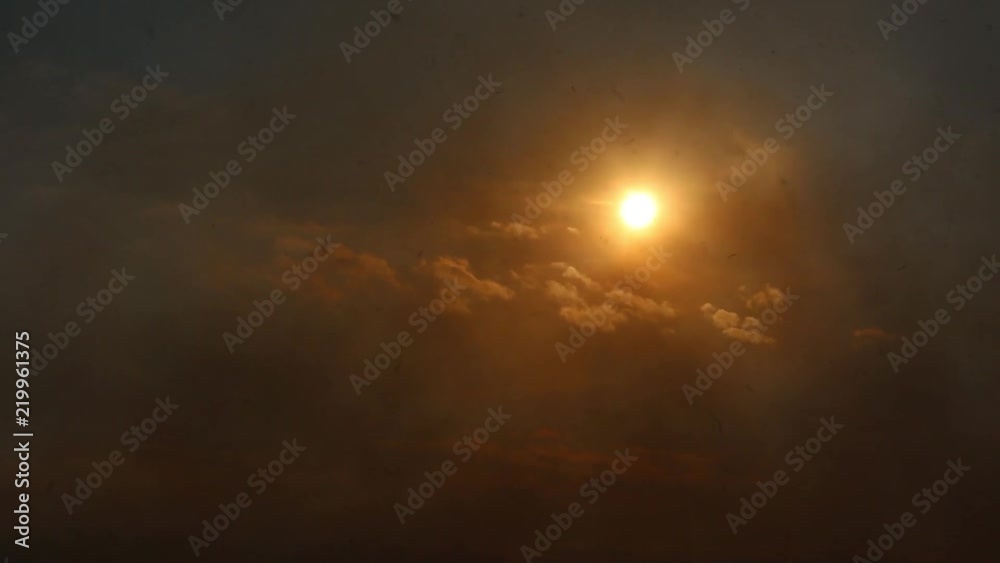 Sunlight through the smoke. Fire on the field. The sky is in smoke Sunlight through the smoke. Fire on the field. The sky is in smoke