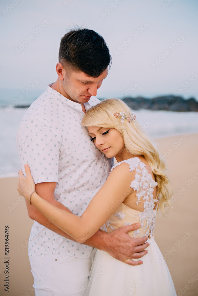 newlyweds standing and hugging on tropical beach newlyweds standing and hugging on tropical beach